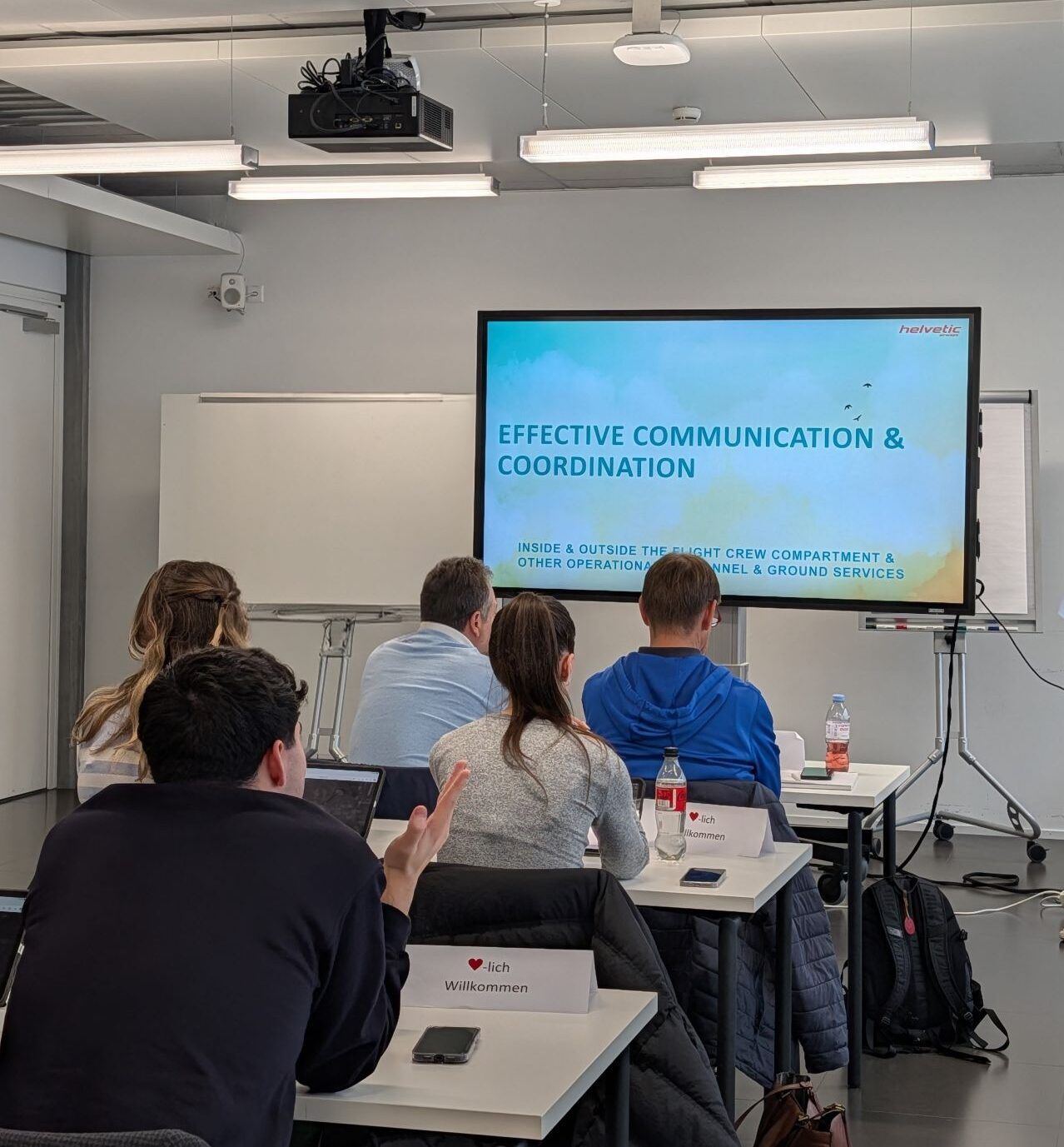 Participants in a classroom facing a slide titled Effective Communication and Coordination.